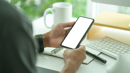 Wall Mural - close up view businesswoman holding smart phone and writing on notebook.