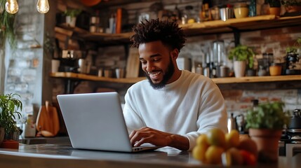 Smiling young man working on laptop in modern kitchen checking email in morning writing message in social network happy young male using internet banking service searching information : Generative AI