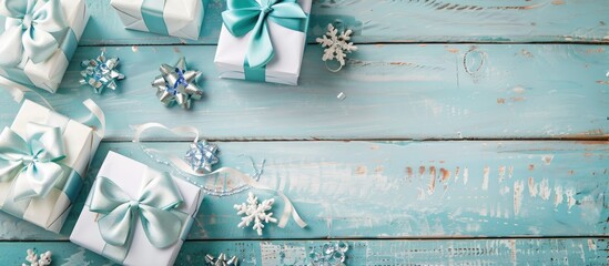 Poster - Holiday photo with copy space image featuring festive decorations of ribbons white and blue gift boxes adorned with charming bows on a bright wooden backdrop