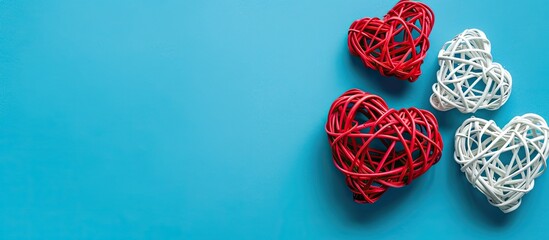 Leinwandbilder - Valentine s Day themed flat lay featuring white rattan hearts with a red heart on a blue background ideal for a greeting card with copy space image