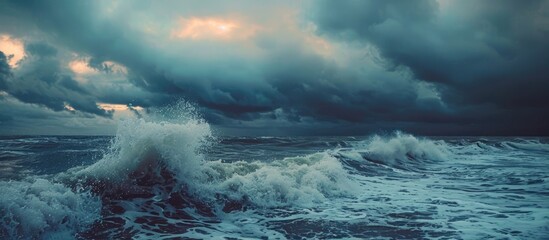 Scenic seascape at dusk with waves crashing under a beautiful cloudy sky Ideal for travel and tourism themes with a nature inspired copy space image for wallpaper design