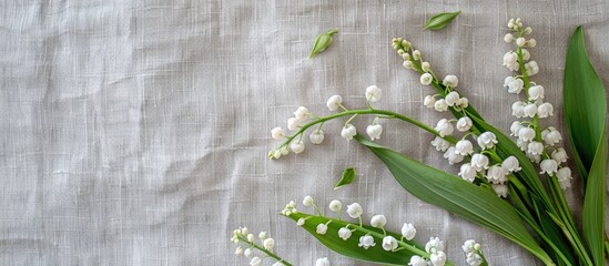 Aufkleber - Top view of a rustic greeting card concept with a bouquet of white lilies of the valley and green leaves on a gray linen background offering ample copy space for cover design