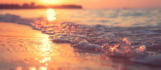 Poster - Sunset on a tropical beach with soft waves and blurred sunlight in the background ideal for a business summer vacation concept with vintage filter style and ample copy space image