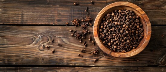 Fototapete - Top view of a wooden table with a bowl of aromatic dry cloves offering a copy space image for text