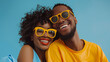 © big_and_serious - Joyful black couple in bright yellow sunglasses, smiling together against a bright blue background
