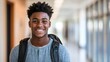 © Hope - Happy African American high school student standing in hallway and looking at camera.