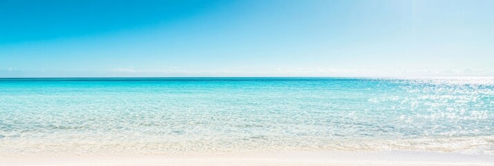 A tropical beach with a clear blue ocean and a sunny sky, featuring a defocused horizon and sparkling water for a natural and relaxing seascape