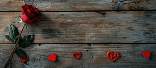 Poster - View from above showing a red rose and heart decorations for Valentine s Day on a wooden surface with clear space for adding text or images. copy space available