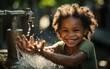 © imagineRbc - A young girl is playing with water from a faucet. She is smiling and she is enjoying herself