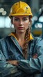 © imagineRbc - A woman wearing a yellow hard hat and blue work clothes. She is looking directly at the camera
