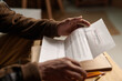 © pressmaster - Close-up of person receiving and holding an eviction notice, focusing on their hands and the document with some text visible, creating sense of urgency and concern