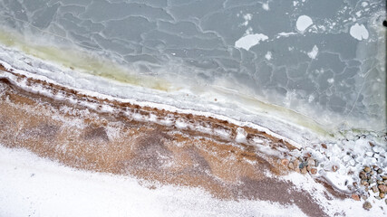 drone aerial view over Helsinki sea line in winter time - beach and marina covered with snow