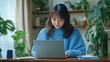 © rifqi - Focused Japanese woman smiles, typing on laptop, surrounded by greenery