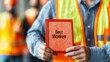 © Whitecatz - Close-up of a worker's hand holding a 'Best Worker' certificate.