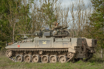 close-up of a soldier in a British army FV510 Warrior Infantry Fighting Vehicle with guns on a battle exercise