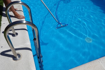 man operates pool cleaner next to a private pool ladder