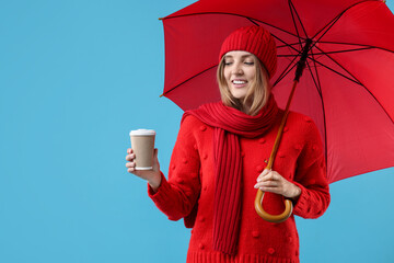 Wall Mural - Woman with red umbrella and paper cup on light blue background, space for text