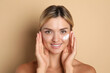 © New Africa - Beautiful woman with cream on her face against beige background