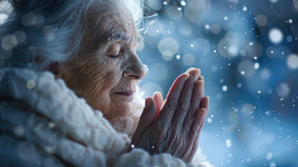 Wall Mural - A photographic portrait of an elderly woman, eyes closed, hands in prayer, sunlight streaming down on her face