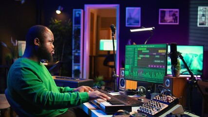 Leinwandbilder - Sound engineer pressing keys of electronic synthesizer and composing new song, adjusting volume levels on pre amp knobs. Composer producing music on piano midi controller, mixing tunes. Camera B.
