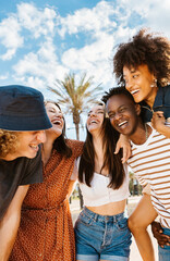 group of multiracial happy young friends having fun together enjoying summer vacation on the beach -