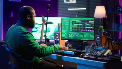 Leinwandbilder - Sound engineer pressing keys of electronic synthesizer and composing new song, adjusting volume levels on pre amp knobs. Composer producing music on piano midi controller, mixing tunes. Camera A.