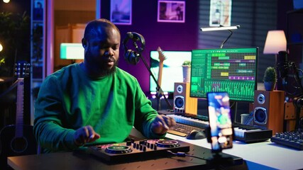 Poster - Skilled audio engineer teaching online mixing tunes lessons by using smartphone on tripod to record himself in home studio. Producer hosting a master class with soundboard console gear. Camera B.