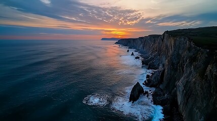 Wall Mural - dramatic coastline view at sunset, with crashing waves and rugged cliffs under a fiery sky, ideal fo
