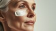 © Jane Kelly - Senior woman with white cream on cheek.  Skincare beauty advertising