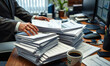 © Photo Builder - A focused shot of a businessman’s hands actively managing and sorting through stacks of business report papers and files
