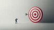 © Taskmanager - A small figure of a businessman stands facing a massive red-and-white bullseye on a gray background, symbolizing the concept of setting and achieving large goals.