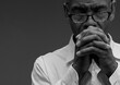 © herlanzer - man praying to god with hands together Caribbean man praying with black grey background with people stock image stock photo