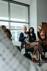 Mature businesswoman speaking at a conference with a smiling diverse audience