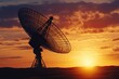 © Suphanny - Satellite dish silhouette at sunset in rural landscape, Silhouette of a large satellite dish against a dramatic sunset, set in a rural landscape, symbolizing communication and technology.