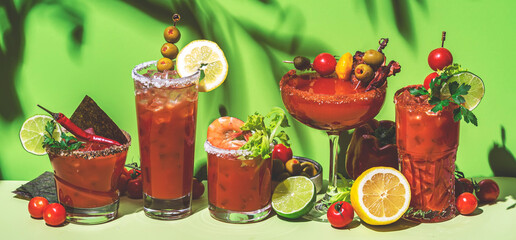 Wall Mural - Tomato juice and vodka alcoholic cocktails with hot sauce, salt, pepper, olives and celery. Bloody mary cocktail party. Green  background, hard light