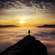 © Qstock - Man Standing on Mountain Peak Above Clouds at Sunrise, Capturing Breathtaking Landscape and Sense of Achievement