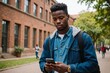 © ThomasLENNE - Low angle view portrait of a cool african student using phone outdoors the university campus