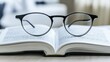 © volga - Close-up of reading glasses on open book
