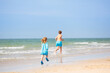 © famveldman - Kids playing on beach. Children play at sea.