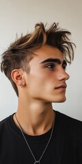 Canvas Print - Young man with stylish haircut posing against a simple background