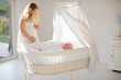 © famveldman - Child watching newborn baby in bassinet.