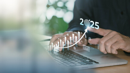 Planning, goal and challenge strategy in new year 2025. Hands typing on a laptop with digital graphs and upward trend lines indicating business growth projections for the year 2025.