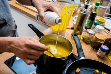 Wall Mural - Chef at the kitchen preparing pumpkin porridge with tofu and vegetables