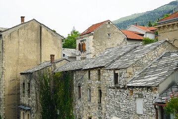 Wall Mural - Traditional architecture of Bosnia and Herzegovina in the Old Town of Mostar: view of old houses with roofs made of stone slabs. Buildings between Kujundjiluk and Marshal Tito streets.