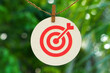 © Ka Iki - Red target symbol on paper hanging on rope with natural bokeh background