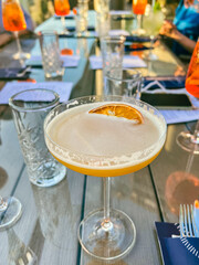 French blonde cocktail in a margarita glass on a wood table with other drinks behind