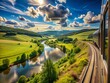 © Man888 - Scenic rural landscape unfolds outside a train window, showcasing rolling hills, lush green forests, and meandering rivers under a bright blue sky with fluffy white clouds.
