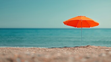 Wall Mural - Orange Umbrella on Sandy Beach by the Calm Ocean Under Clear Sky