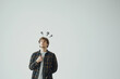 © BetterPhoto - Pensive young man with question marks above his head, symbolizing curiosity, decision-making, and problem-solving in everyday situations, on a minimalistic background.