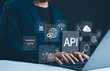 © Supatman - API Application Programming Interface Concept. A programmer types on a laptop, interacting with digital icons representing API development, security, and cloud computing. Application Software Tool,
